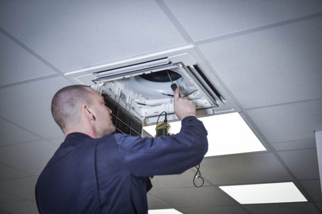 Servicetechniker der ISB GmbH bei der Wartung einer Deckenklimaanlage in Burghausen